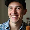 Smiling male guitar student holding a plectrum